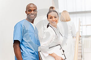 Two cheerful doctors looking over shoulder and smiling while the