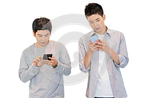 Two cheerful friends wear gray t-shirts standing isolated over white background, holding mobile phone.Couple of cool guys using