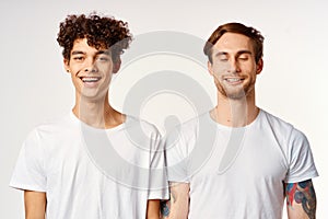 Two cheerful friends in white t-shirts emotions studio