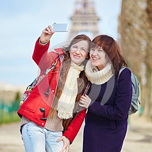 Two cheerful girls in Paris doing selfie