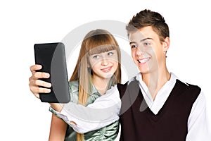 Two cheerful teenagers staring into tablet