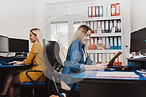 Two cheerful women working with computers