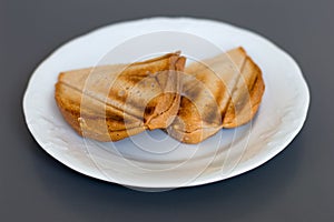Two cheese sandwish on white plate.
