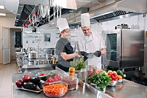 Two chefs discuss the menu in the kitchen of a restaurant or hotel.