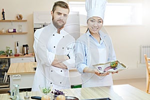 Two Chefs Posing in Kitchen
