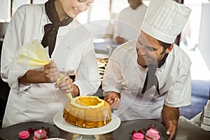 Two chefs preparing a cake