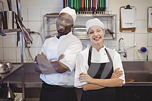 Two chefs standing with arms crossed in the commercial kitchen