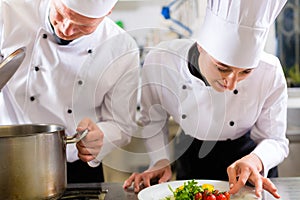 Two chefs in team in hotel or restaurant kitchen