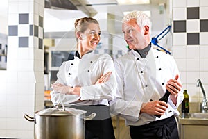 Two chefs in team in hotel or restaurant kitchen