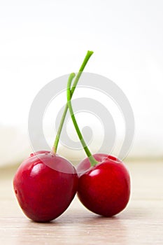 two Cherries Close-up. Cherry on wood and white background. - healthy eating and food concept