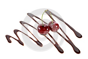 Two cherries in liquid chocolate on white background