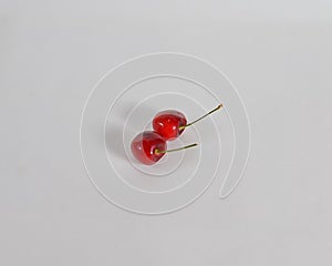 Two cherries on white background