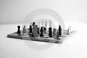 Two chess teams one in front of other on the chessboard. white background