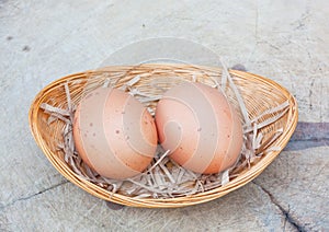 Two chicken eggs in bamboo basket