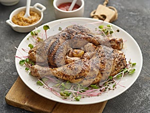 Two chicken legs grilled with garlic on a white plate