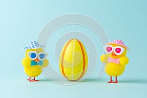 Two chickens with colorful easter egg on blue background. Easter minimal concept. Creative Happy Easter or spring layout