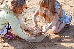 Two child girls are playing with sand