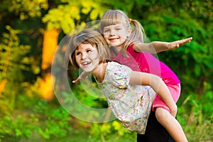 Two child girls playing together. Sisters play Superhero. Happy kids having fun, smiling and hugging.