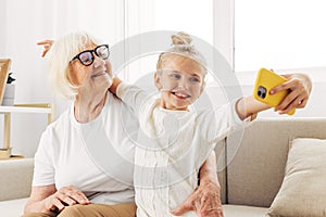 Call sofa granddaughter child video selfie hugging family bonding smiling togetherness phone grandmother education