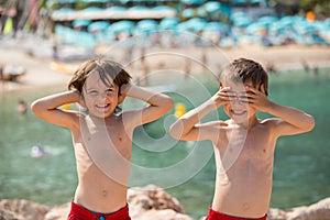 Two children on the beach, boys, playing and making funny faces