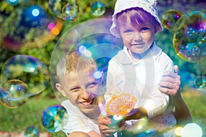 Two children blow bubbles
