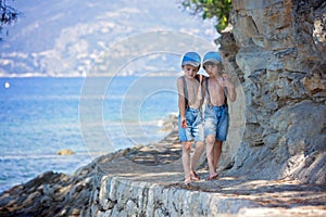 Two children, boy brothers, walking on a path around mediterranian sea on French riviera photo