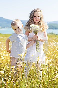 Two children boy and girl at camomile field