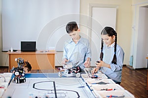 Two children, brother with sister enaging in their hobby-constructing robot toys