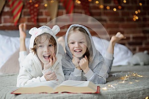 Two children, brother and sister, read Christmas tales.