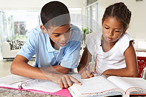 Two Children Doing Homework In Kitchen