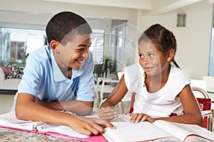 Two Children Doing Homework Together In Kitchen