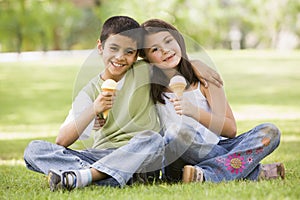 Two children eating ice cream in park