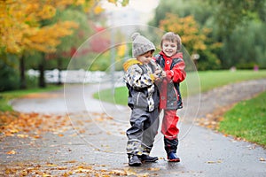 Two children, fighting over toy in the park on a rainy day