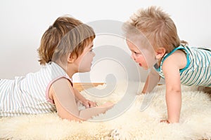 Two children on fur carpet