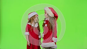 Two children girls swear and argue, they are in colorful costumes. Green screen