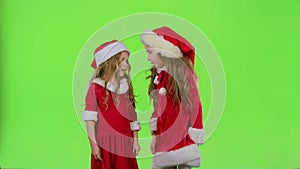 Two children girls swear and argue, they are in colorful costumes. Green screen. Slow motion