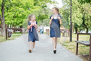 Two children go to school with backpacks. Concept back to school, learning, friendship and childhood