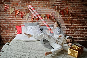 Two children have put up cheerful fight on a big bed.