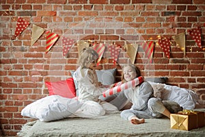 Two children have put up cheerful fight on a big bed.