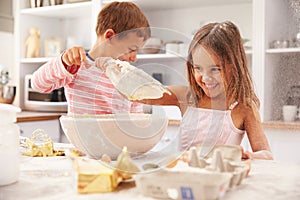 Two children having fun baking in the kitchen