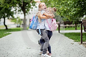 Two children hug and laugh. The concept of school, study, education, friendship, childhood.