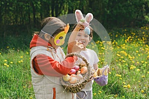 Two children hunt for Easter eggs in a spring garden. Easter tradition