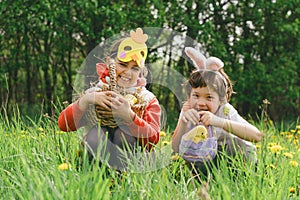 Two children hunt for Easter eggs in a spring garden. Easter tradition