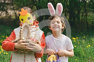 Two children hunt for Easter eggs in a spring garden. Easter tradition