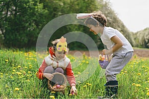 Two children hunt for Easter eggs in a spring garden. Easter tradition