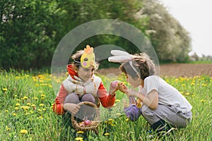 Two children hunt for Easter eggs in a spring garden. Easter tradition