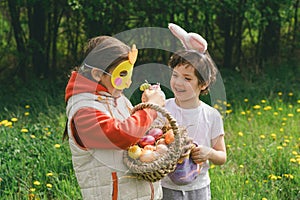 Two children hunt for Easter eggs in a spring garden. Easter tradition