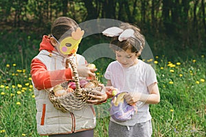 Two children hunt for Easter eggs in a spring garden. Easter tradition