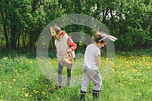 Two children hunt for Easter eggs in a spring garden. Easter tradition