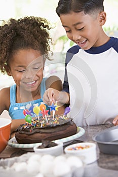 Two children in kitchen with birthday cake